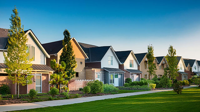 a row of houses with green grass in front