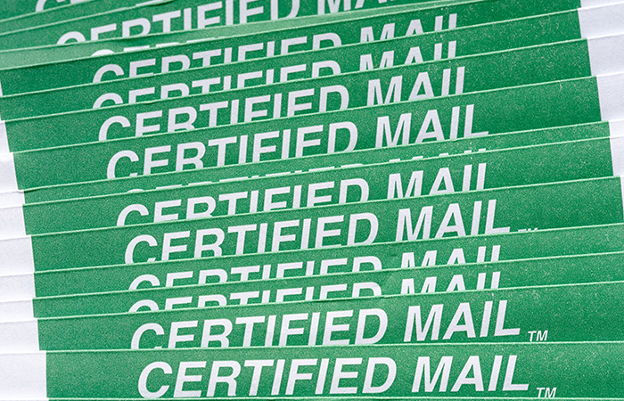 Certified mail label on certified mail envelopes fanned out in a row.